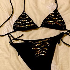 String bikini in black with gold embellishment. Gently worn suit with no damage.